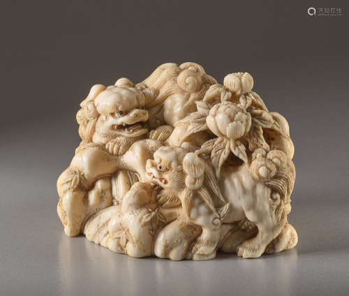 AN IVORY NETSUKE BY SHOUNSAI OF SHISHI PLAYING IN ...