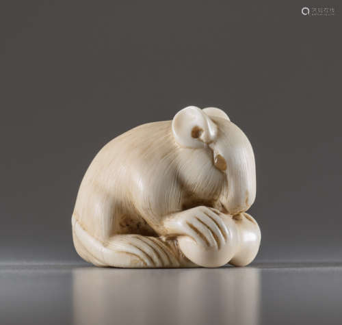 AN IVORY NETSUKE BY IKKO OF A RAT WITH DOUBLE GOUR...