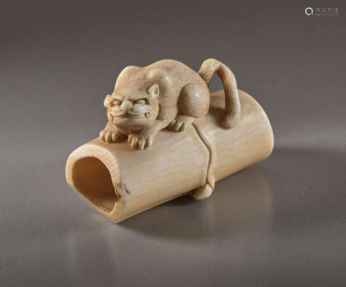 AN IVORY NETSUKE BY SHIGEMASA OF A TIGER ON BAMBOO...