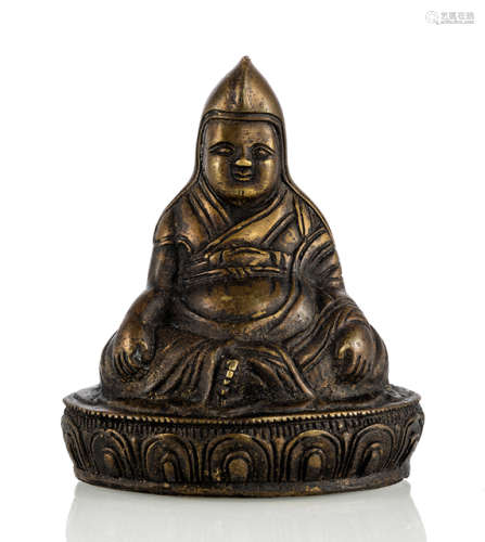 A BRONZE FIGURINE OF A LAMA