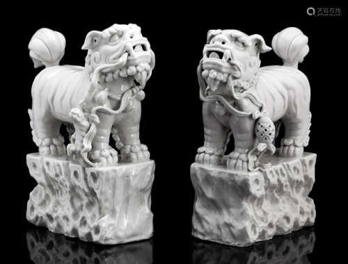 A PAIR OF BLANC DE CHINE LIONS ON ROCK-SHAPED BASES