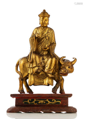 A LACQUERED AND GILT-WOOD FIGURE OF A PRIEST RIDING AN OX