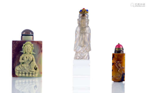 A GLASS SNUFF BOTTLE IN THE SHAPE OF A STANDING DEITY AND TWO SOAPSTONE SNUFF BOTTLES