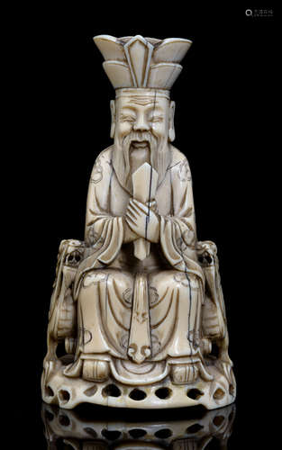 A FINELY CARVED IVORY MODEL OF A SEATED DAOIST IMMORTAL