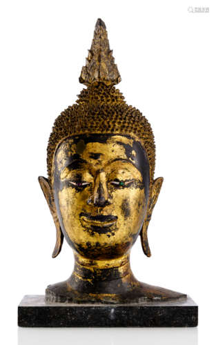 A GILT- AND BLACK-LACQUERED BRONZE HEAD OF BUDDHA SHAKYAMUNI