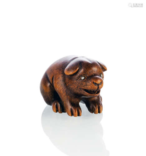 A CARVED BOXWOOD NETSUKE OF A PUPPY