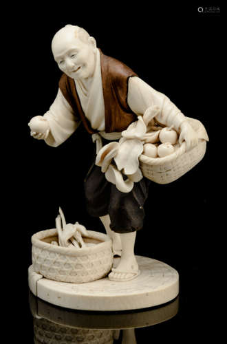 A BOXWOOD AND IVORY OKIMONO OF A FRUIT AND VEGETABLE SELLER