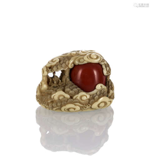 A FINE CARVED IVORY CRANE NEST WITH A MOVABLE CORAL BEAD