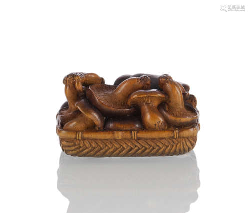 A FINE CARVED WOOD NETSUKE OF A GROUP OF SHITAKE MUSHROOMS IN A BASKET