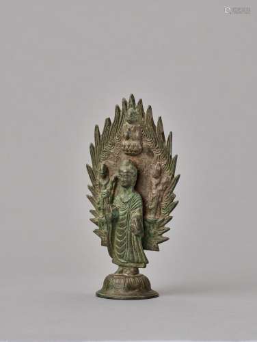 A BRONZE BUDDHA STANDING IN FRONT OF A FLAMING HALO, DATED 571