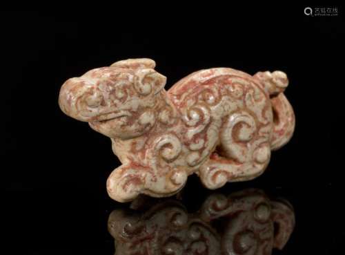 A MINISCULE CROUCHING ANIMAL WITH AN INTRICATE PATTERN OF CARVED CURLS