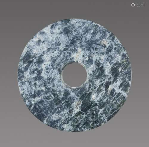 A RICHLY TEXTURED NEOLITHIC BI DISC IN GREEN JADE WITH A STRIKING MARBLE-LIKE PATTERN
