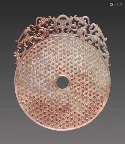 A GORGEOUS DISC IN WHITE JADE CARVED WITH CONFRONTING DRAGONS IN OPENWORK AND A PATTERN OF RAISED SCROLLS
