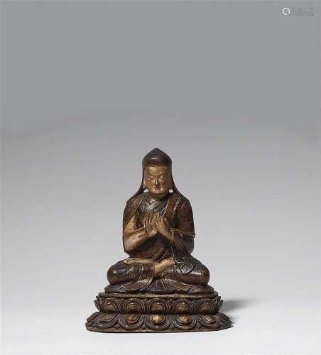 A Tibetan black lacquered and gilt wooden figure of a Sakya lama, probably Kunga Gyaltsen (1182-1251). 15th/16th century