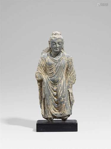 A Gandhara grey schist figure of a standing Buddha. Pakistan. 2nd/3rd century