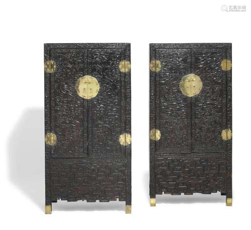 A pair of richly carved Chinese hardwood cupboards. Qing, late 19th century/ early 20th century. H. 174 cm. W. 88 cm. D. 58 cm. (2).