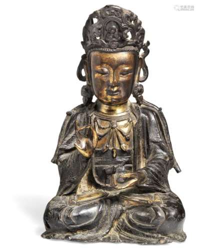 A Chinese patinated and partly gilt bronze figure of Guanyin. Ming 1368-1644. H. 20 cm.