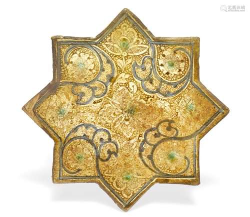 A Kashan ceramic star shaped tile with lustre over white and blue glaze, decorated with foliage. Iran, 13th century. W. 21 cm.