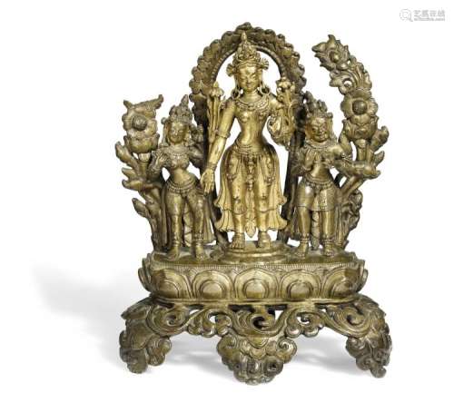 A Tibetan patinated and gilt bronze figuregroup of Tara with acolytes. 16th-17th century. Weight 814 gr. H. 15 cm.