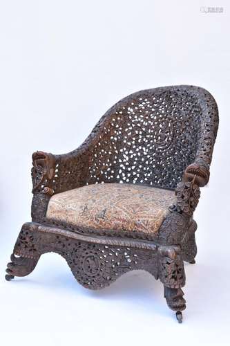 AN INDIAN CARVED WOODEN ARMCHAIR