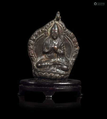 A bronze pendant depicting Lama seated on a lotus flower, Tibet, 13th-14th century