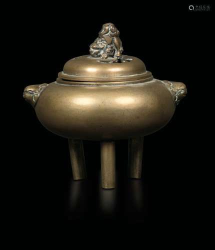 A tripodal gilt bronze censer with mascaron handles and a Pho dog on the lid, China, Qing Dynasty, 19th century