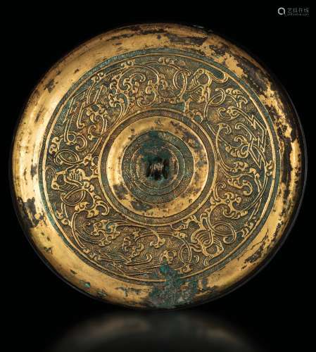 A gilt bronze mirror with embossed decors, China, Han Dynasty (206 b.C.-220 A.D.)