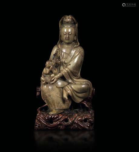 A rare and finely carved soapstone Guanyin with child, China, Qing Dynasty, Qianlong period (1736-1796)