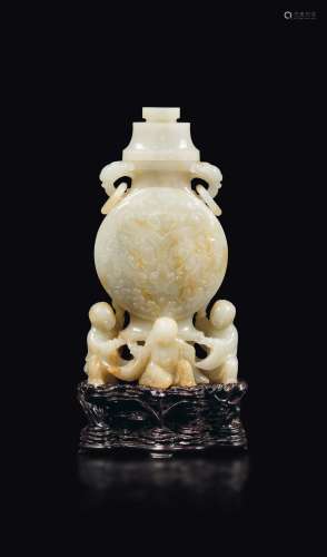 A white and russet jade vase with lid with a taotie mask decor, ring handles with Pho dog mascarons, held up by figures of children, China, Qing Dynasty, Qianlong period (1736-1796)