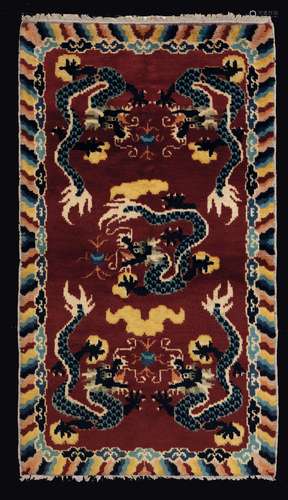 A carpet with a dragon embroidery on a ruby backdrop, China, Qing Dynasty, late 19th century