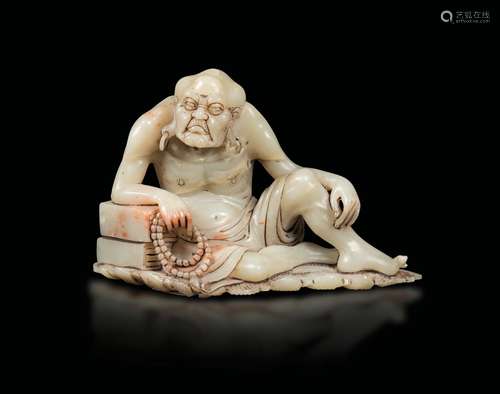 A carved soapstone figure of a wiseman with prayer beads, China, Qing Dynasty, late 19th century