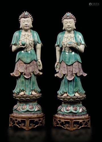 A pair of glazed biscuitware standing Buddhas holding peaches, China, Qing Dynasty, Kangxi Period (1662-1722)