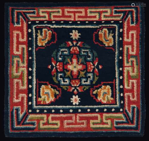 A meditation mat with a central medallion on a blue backdrop and a meander frame, Tibet, 19th century