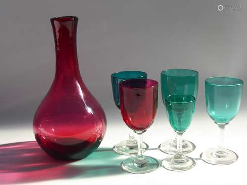 A Victorian Cranberry Glass Decanter together with a four Victorian port/wine glasses (three green, one red) and a green sherry glass.