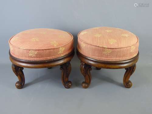 A Pair of Mahogany Victorian Carved Footstools, having been re-upholstered in dusky pink linen.