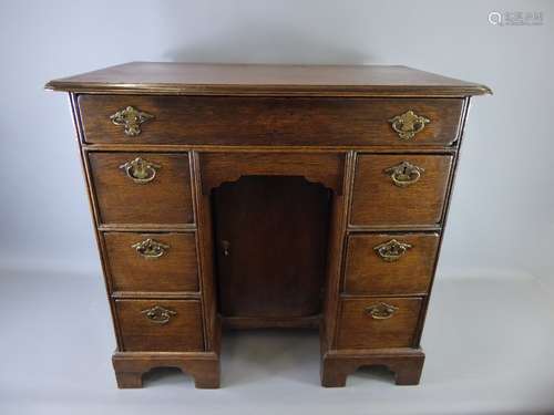 An Antique small Knee-hole Desk, the desk having one long drawer, six other drawers, on bracket feet, approx 74 x 47 x 69 cms.