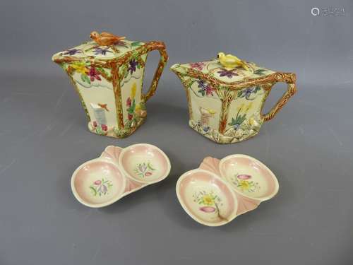 A Pair of Wadeheath Teapots, the teapots with floral and stem designs in relief, the lids bearing the figure of a bird (the bird on one lid damaged),. The larger teapot approx 15 cms high, smaller is approx 12 cms high, together with two Susie Cooper poached egg dishes (one damaged). (4)