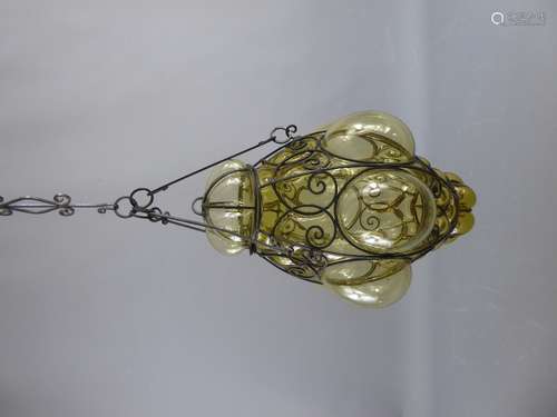 An Arts and Crafts Wrought Iron  Lantern. The lantern has the original hanging with light made in two sections of pale amber glass, approx 46 cms.