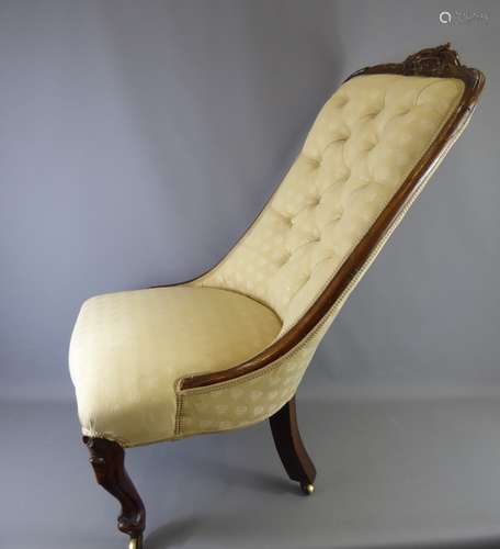 An Antique Elm Button-Back Nursing Chair, with cabriole legs on brass casters and covered in beige fabric.