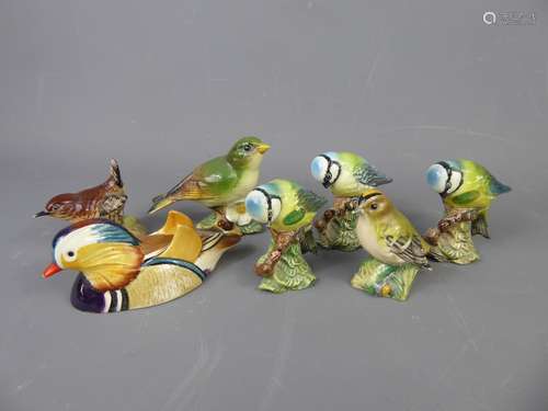 A Collection of Vintage Beswick Birds, including three Blue Tits, no. 992, a Wren, no. 993, a Greenfinch, no. 2015, a Mandarin Duck, no. 1519-1, marks to base 'Approved by Peter Scott', together with a Goldfinch, no. 2415 (af).