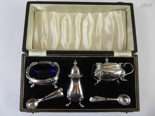 A Silver Cruet Set, comprising mustard, salt cruet, pepper and four silver-plated salt spoons, Birmingham hallmark, mm Adie Bros, presented in the original box.