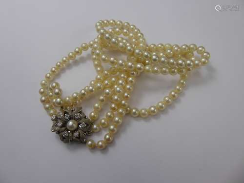 A Vintage Three-Strand Cultured Pearl Necklace, with silver, white stone floral clasp, approx 5mm each pearl, approx 33 cms length.