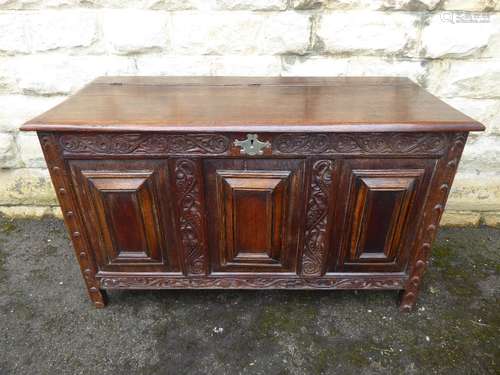 A Large Antique Oak Coffer, with hinged lid, the coffer having three panels to front with attractive carvings and supported on bracket feet, approx 120 x 54 x 70 cms.