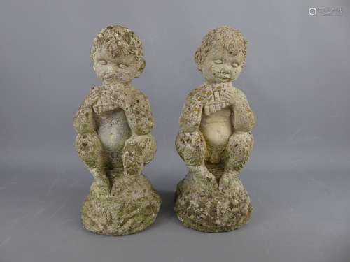 A Pair of Composite Stone Weathered Garden Figures of children playing flutes. (2)