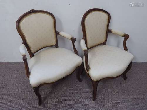 A Pair of Oak Salon Chairs, with carving to the frame, cabriole legs and covered in a cream fabric.