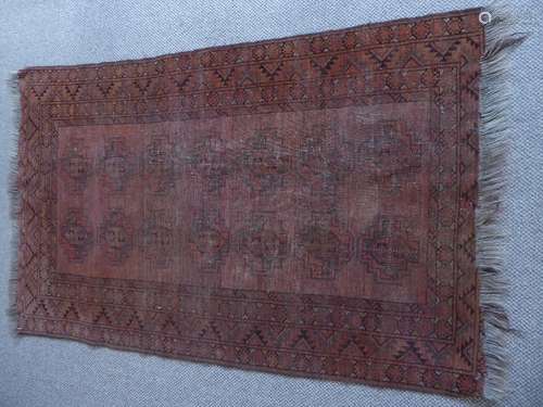 An Antique Rug with a red/brown background and abstract geometric shapes arranged in rows, approx 158 x 100 cms.