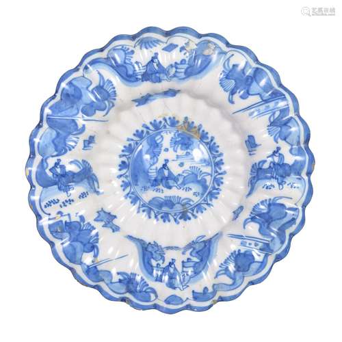 A Dutch Delft blue and white dish in the Transitional style, circa 1700, of fluted …