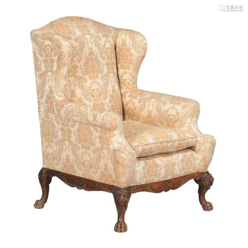 A mahogany and floral upholstered wing armchair in George III style