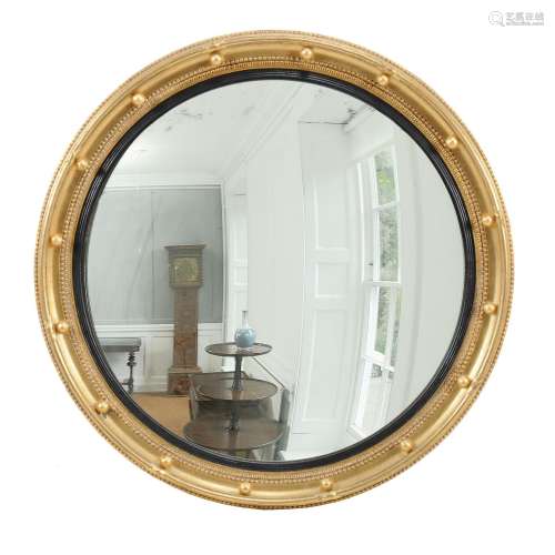 A giltwood convex wall mirror in Regency style