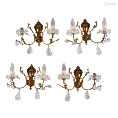 A set of four gilt metal and moulded glass twin light wall appliques